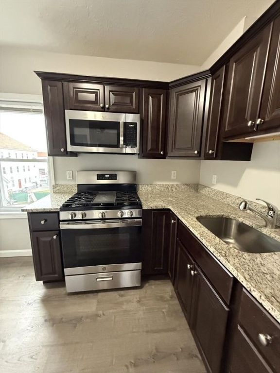 a kitchen with granite countertop stainless steel appliances and wooden cabinets
