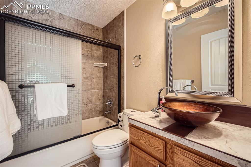 46 Barr Lake Circle Divide, CO 80814 - Photo 22 of 47 a bathroom with a granite countertop sink a toilet a mirror and shower