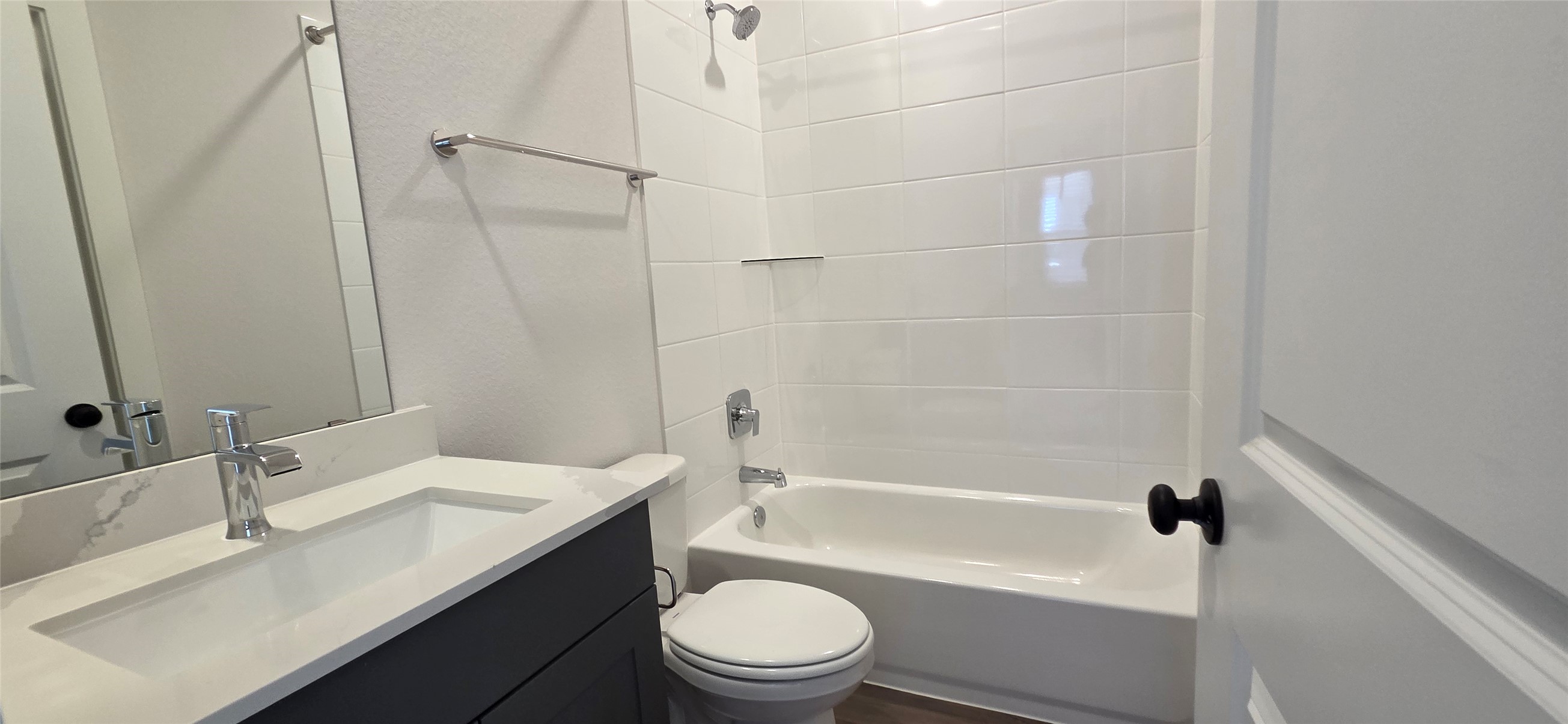 8107 Wilder Road Austin, TX 78736 - Photo 18 of 35 A well-appointed bathroom features a sleek vanity, a modern tub with tiled surround, and stylish fixtures.