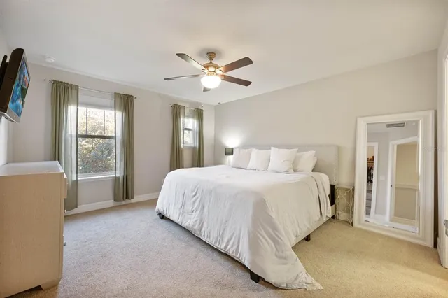a bedroom with a large bed chandelier and a window