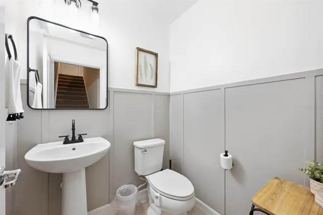 a bathroom with a toilet a sink and mirror