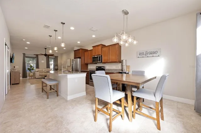a kitchen with kitchen island a dining table and chairs