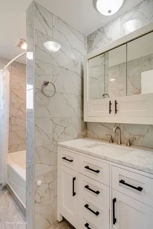 a bathroom with a granite countertop sink a mirror and shower