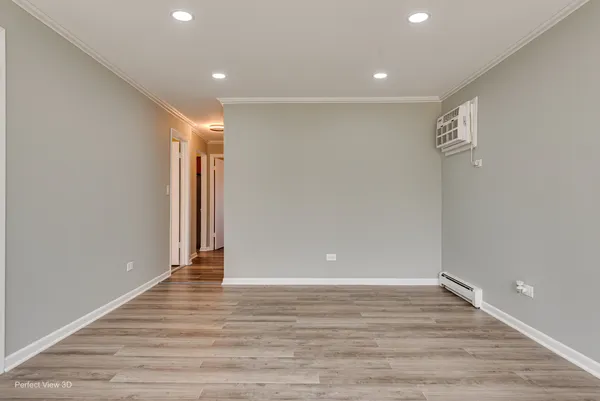 a view of an empty room with wooden floor
