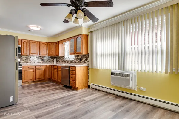a kitchen with granite countertop wooden floors stainless steel appliances and a window