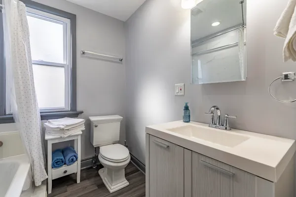 a view of a room that has a bed with wooden floor