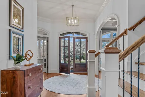 a view of a dining room with furniture a chandelier and wooden floor
