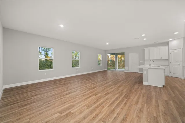 a kitchen with granite countertop a sink a stove top oven and cabinetry