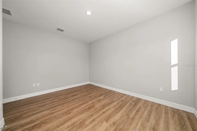 a view of a room with wooden floor and window