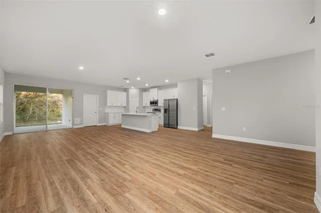 a view of a kitchen with wooden floor and a window