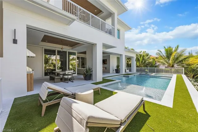 a view of a house with swimming pool and sitting area