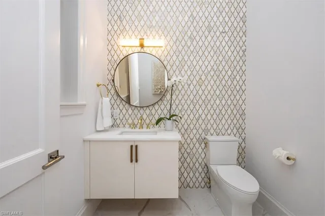 a bathroom with a toilet a sink and mirror