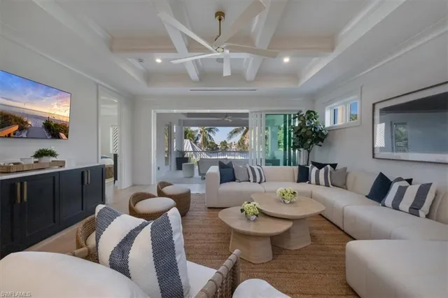 a living room with furniture a large window and a chandelier