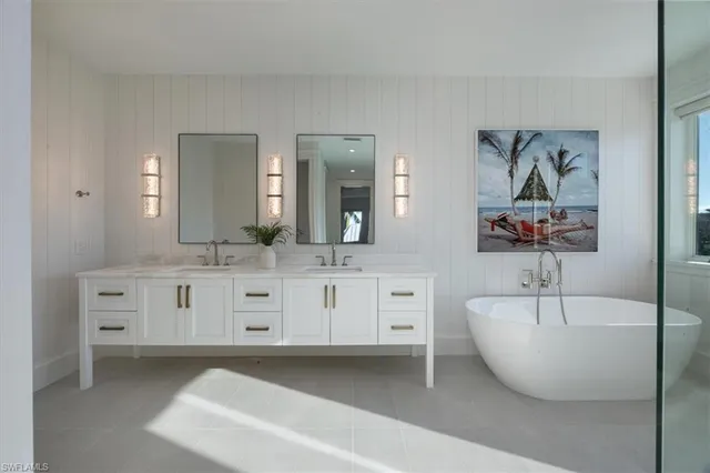 a bathroom with a double vanity sink mirror and bathtub