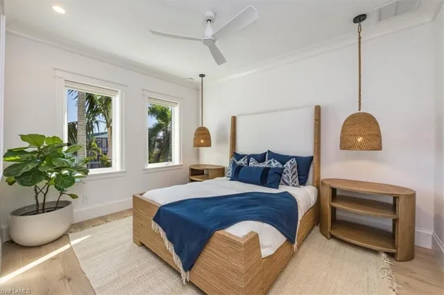 a spacious bedroom with a balcony a bed and a potted plant