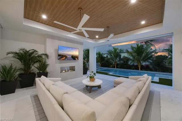 a living room with patio furniture and a potted plants