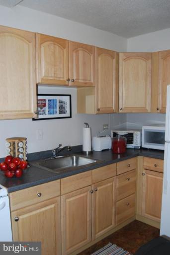 1311 Delaware Avenue Southwest, Unit S147 Washington, DC 20024 - Photo 6 of 18 a kitchen with stainless steel appliances granite countertop white cabinets sink and a granite counter top
