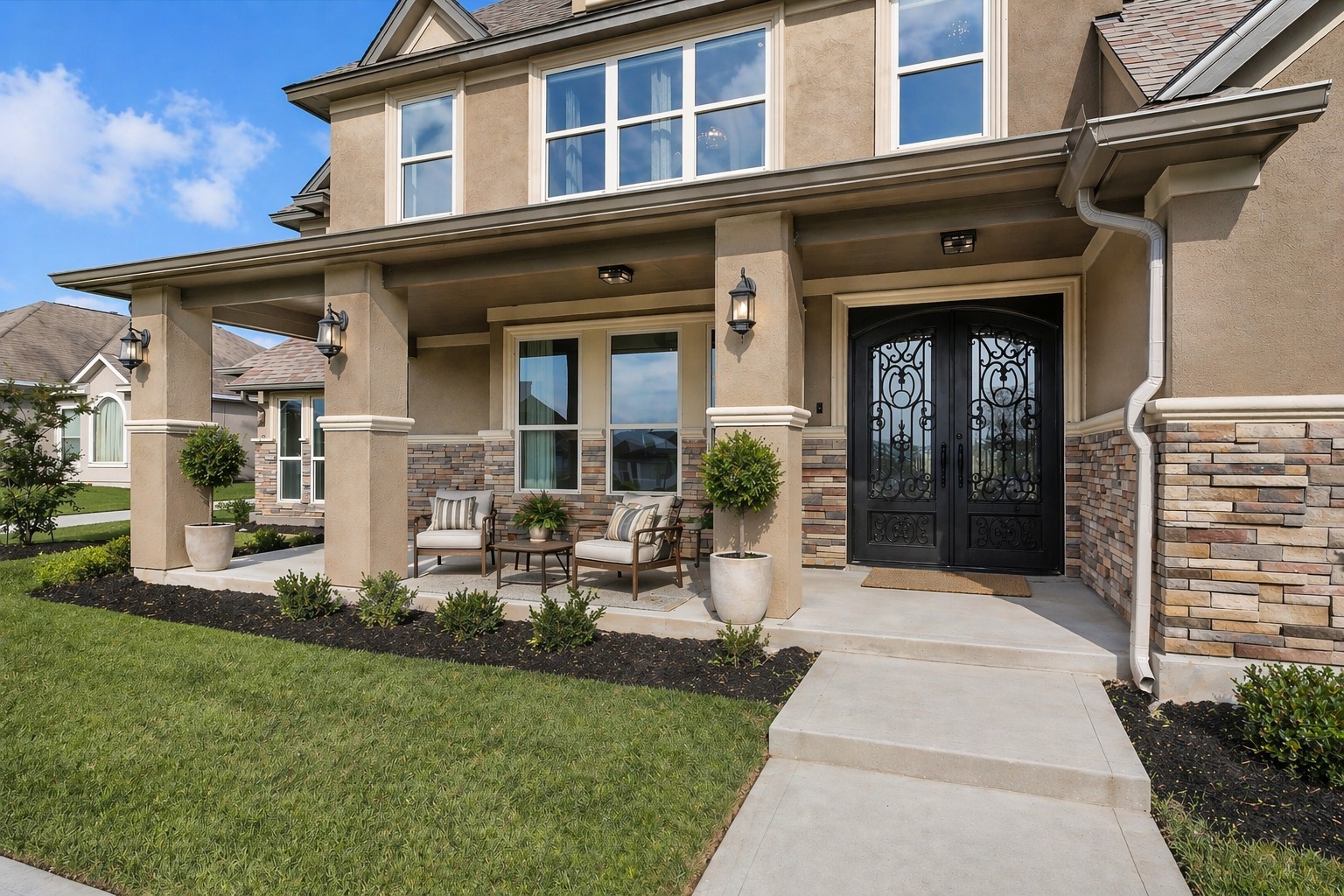 10887 Decatur Street Willis, TX 77318 - Photo 6 of 50 Clean, well-kept front elevation with a welcoming covered porch and strong curb appeal. The stone-accented exterior pairs nicely with the warm stucco tones, while the double iron front doors create a bold focal point. Tall columns frame the entry and provide a spacious, shaded sitting area.