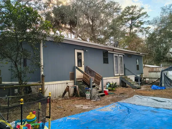 a view of backyard with wheel chair and wooden fence