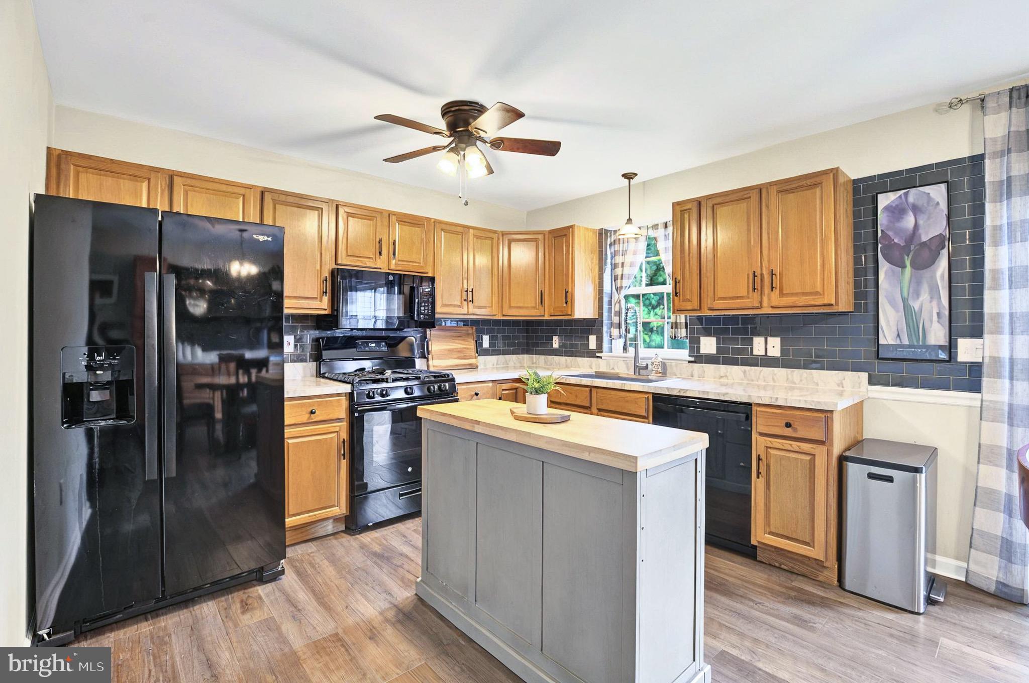 20 Pebble Creek Drive Lititz, PA 17543 - Photo 13 of 45 a kitchen with stainless steel appliances granite countertop a refrigerator a sink dishwasher a stove with wooden cabinets and floor