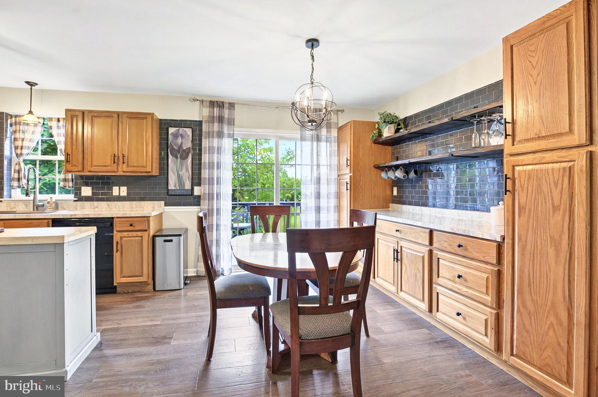 20 Pebble Creek Drive Lititz, PA 17543 - Photo 10 of 45 a open kitchen with stainless steel appliances granite countertop a stove top oven a sink a dining table and chairs with wooden floor