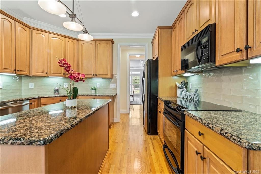 142 Spring Branch Road Fort Mill, SC 29715 - Photo 10 of 48 a kitchen with stainless steel appliances granite countertop a sink a stove and a wooden cabinets