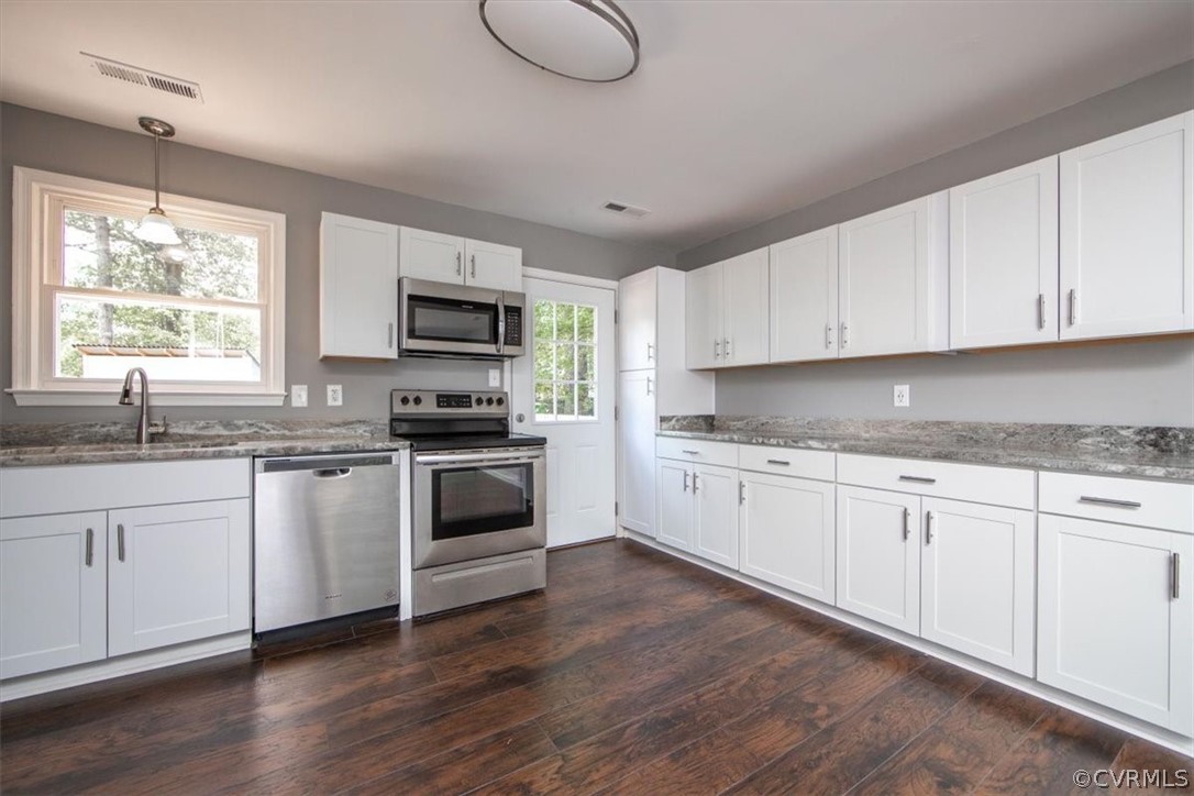 9301 Telstar Drive Richmond, VA 23237 - Photo 8 of 24 a kitchen with granite countertop white cabinets and white appliances