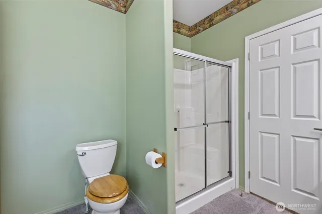 a white toilet sitting next to a shower