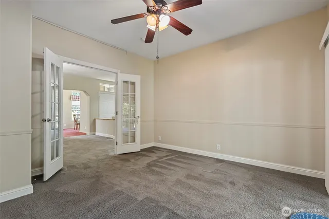 an empty room with closet and a chandelier fan