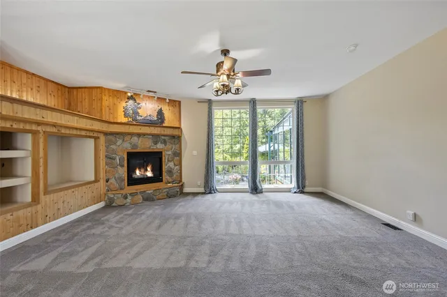 a view of an empty room with a fireplace and a window