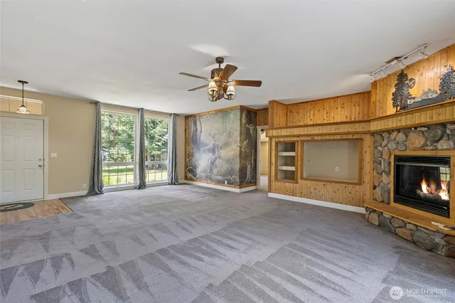 a view of an empty room with a fireplace and a window
