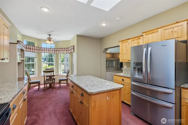a kitchen with granite countertop a refrigerator and a stove top oven