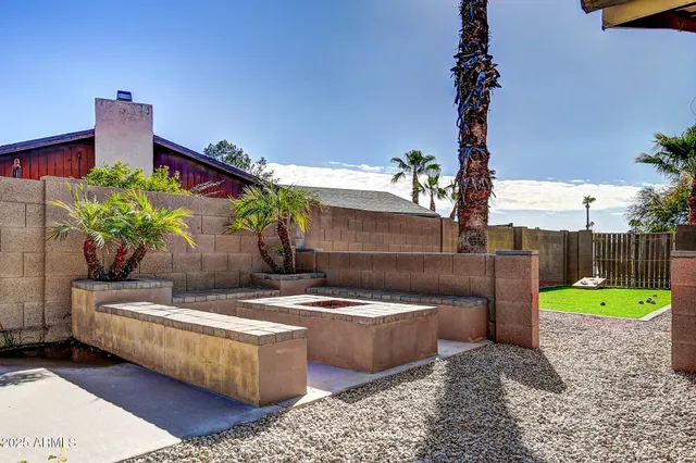 a view of a backyard with table and chairs with wooden fence