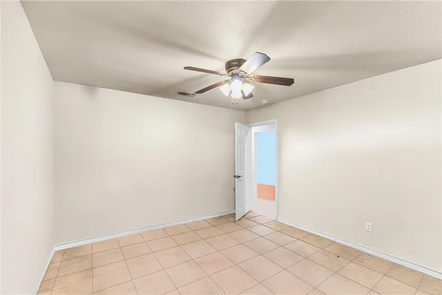 an empty room with chandelier fan