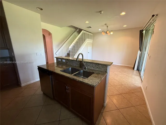 a kitchen with stainless steel appliances granite countertop a sink and a refrigerator