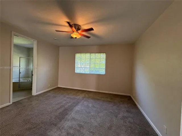 an empty room with closet and a ceiling fan