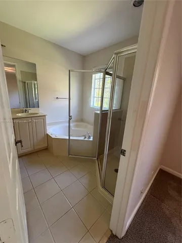 a bathroom with a tub sink and mirror