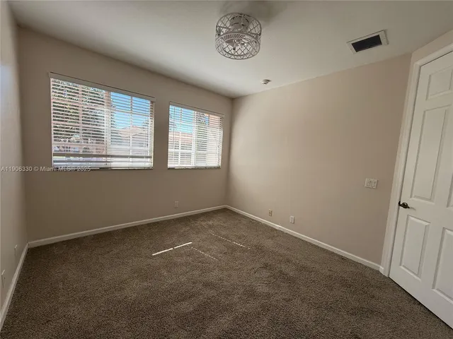 a view of an empty room with a ceiling fan