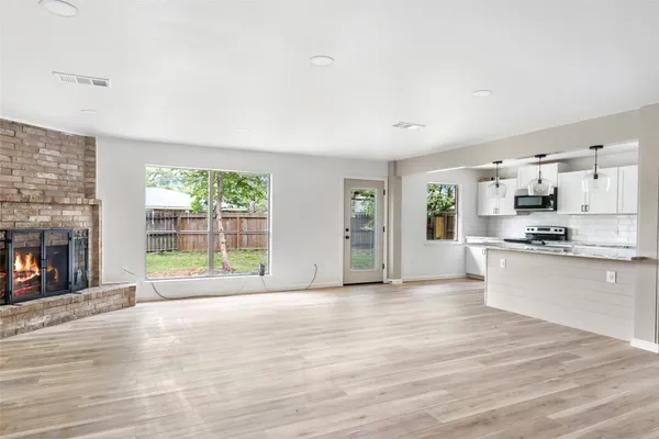 an empty room with wooden floor and fireplace