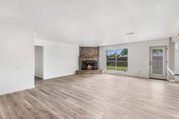 a view of a room with wooden floor and windows