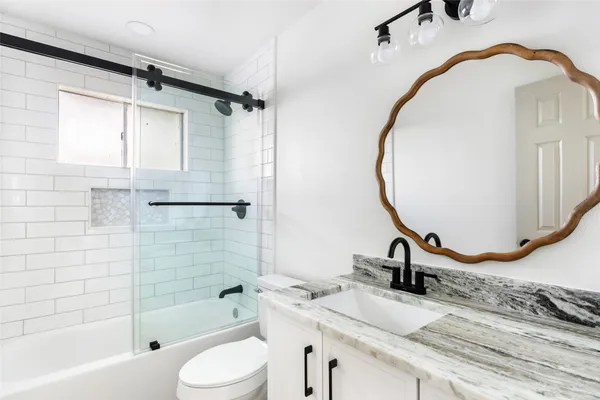 an empty room with wooden floor and window