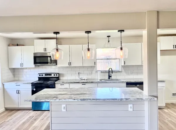 a kitchen with stainless steel appliances granite countertop a sink and a stove