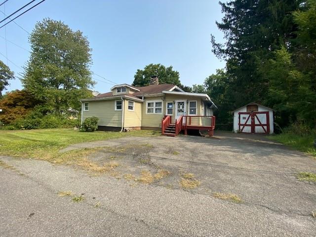 a front view of a house with a garden and tree