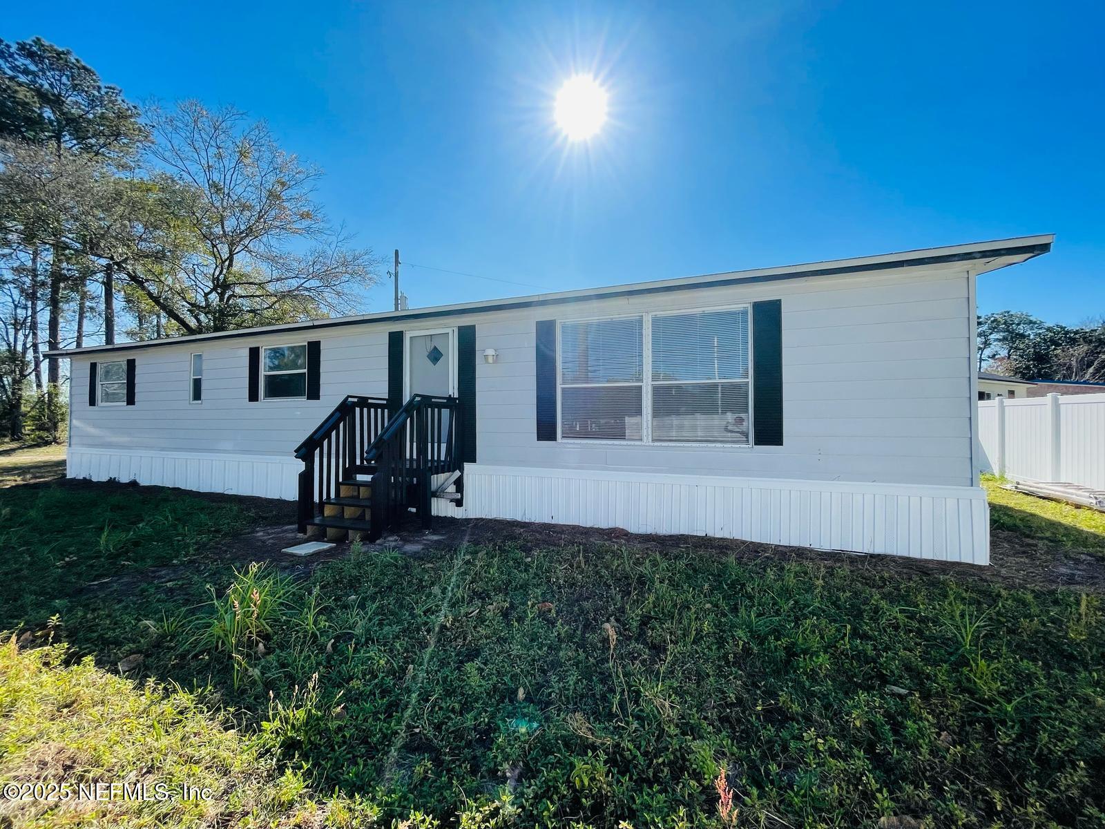a view of a house with backyard and a tree