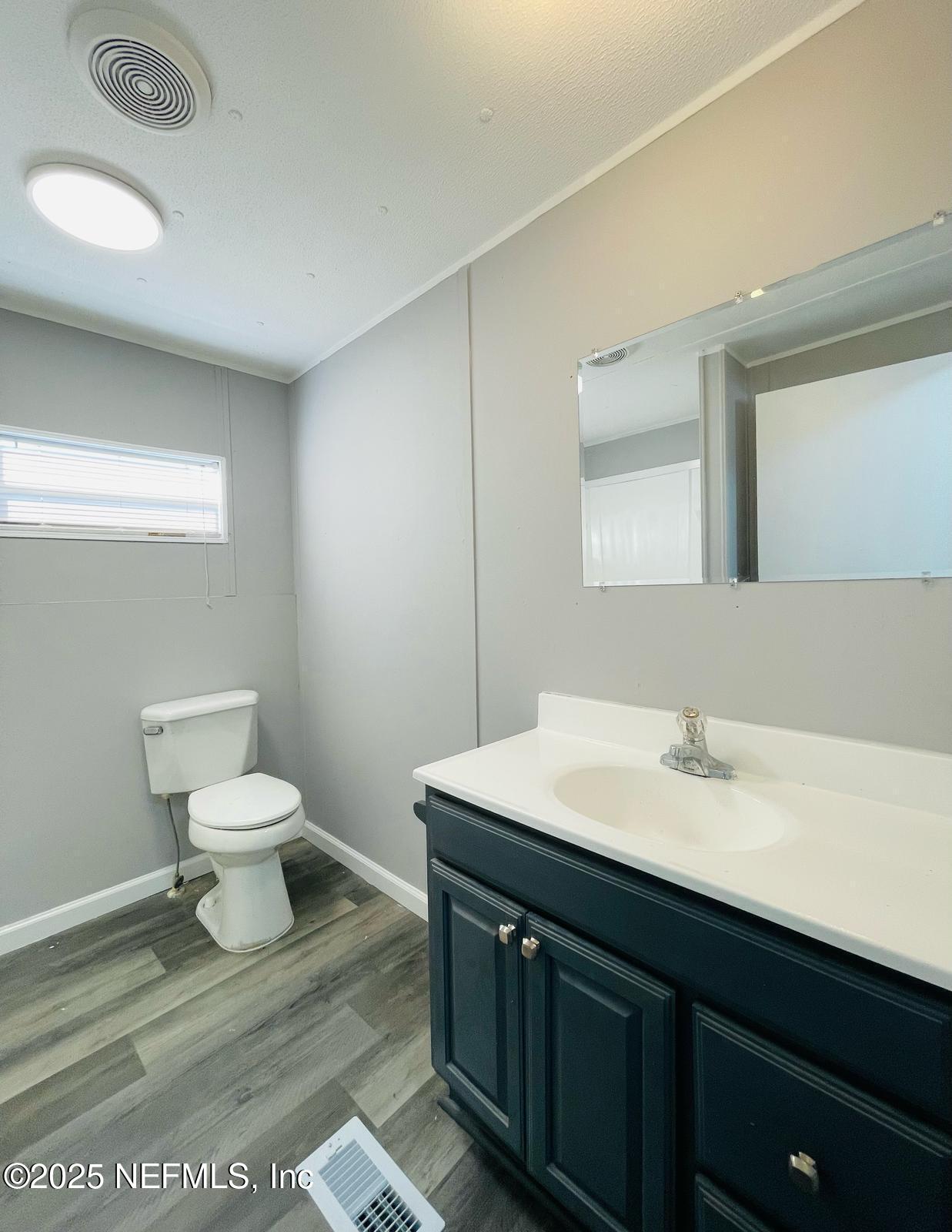 8660 Maynard Place Jacksonville, FL 32222 - Photo 8 of 14 a bathroom with a toilet a sink and mirror