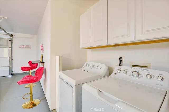 a utility room with dryer and cabinets