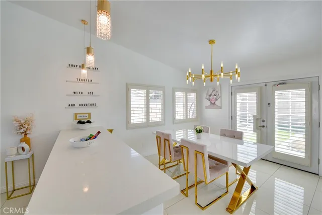 a dining room with furniture a chandelier and wooden floor