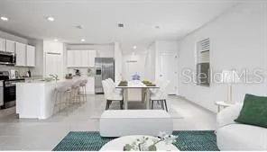 a living room with furniture and a dining table with kitchen view