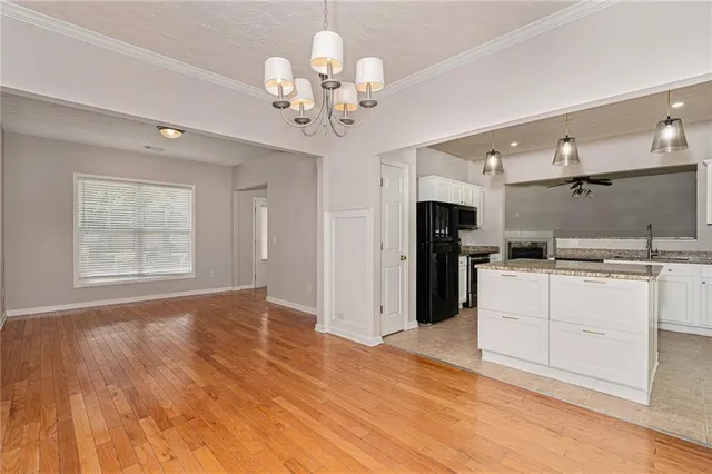 a view of a kitchen with refrigerator and wooden floor