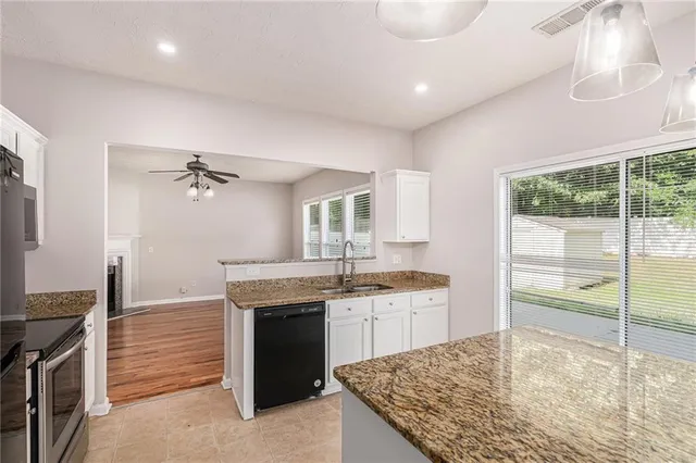 a kitchen with kitchen island a sink stainless steel appliances and cabinets